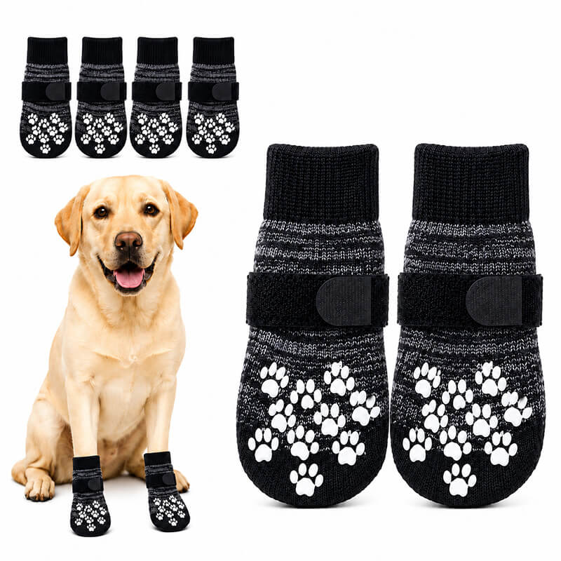 Vier dunkelgraue Anti-Rutsch Hundesocken mit weißen, gummierten Pfotenabdrücken auf der Unterseite und schwarzen Klettverschlüssen für sicheren Halt an den Hundepfoten