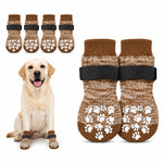 Zwei Paar dunkelbraune, gestrickte Hundesocken mit weißen Anti-Rutsch-Noppen im Pfotenmuster und verstellbaren, schwarzen Klettverschlüssen für optimalen Pfotenschutz und sicheren Halt auf glatten Böden
